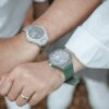 A couple holding hands, showcasing stylish wrist watches.