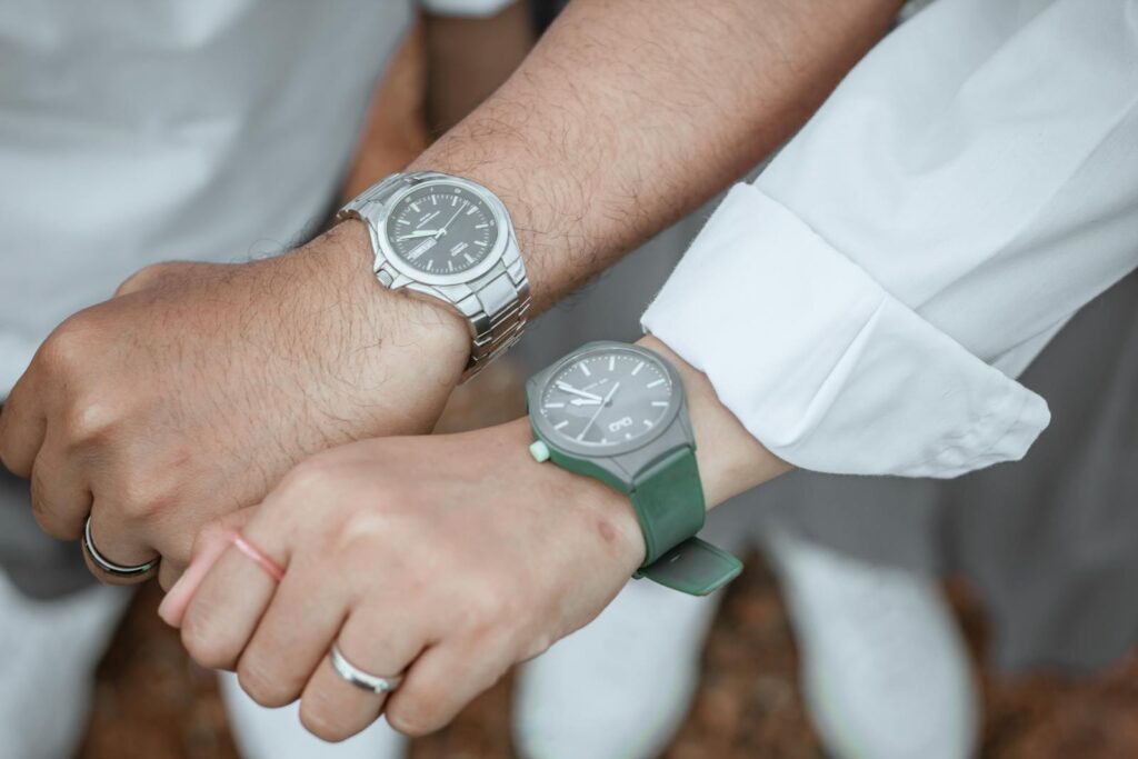 A couple holding hands, showcasing stylish wrist watches.