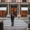 man in black jacket walking on pedestrian lane during daytime